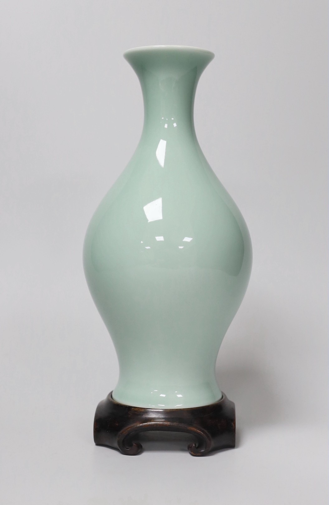A Chinese celadon glazed vase, hallmark to base, wood stand. 24.5cm high